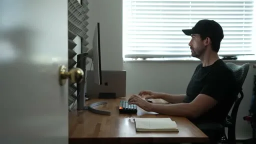 A documentary creator writing a script at a desk before shooting, planning the story structure ahead of production